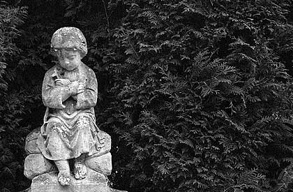 Lost in silent sorrow: A little mourner made of stone in Hietzing.